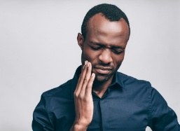 Man with toothache holding cheek