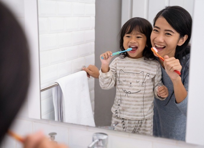 Mother and child brushing teeth to prevent dental emergencies