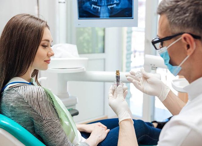 Dentist explaining model of dental implants in Palo Alto