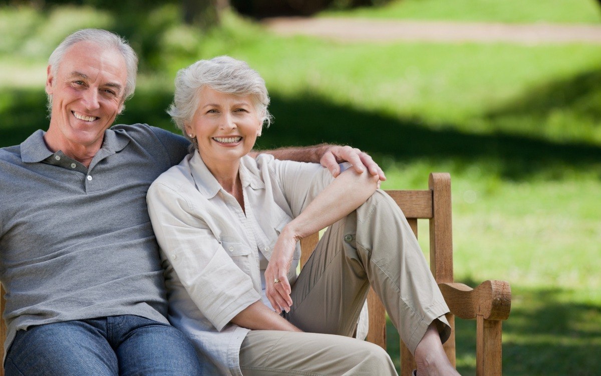 Older couple sharing healthy smiles after restorative dentistry