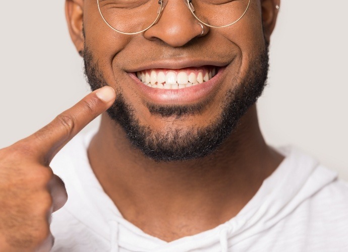 Man pointing to smile after scaling and root planing gum disease treatment