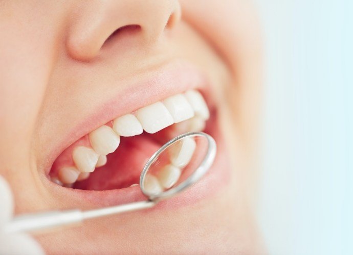 Dentist examining patient's smile after tooth colored filling restoration