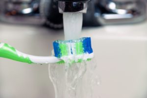 running toothbrush under water 